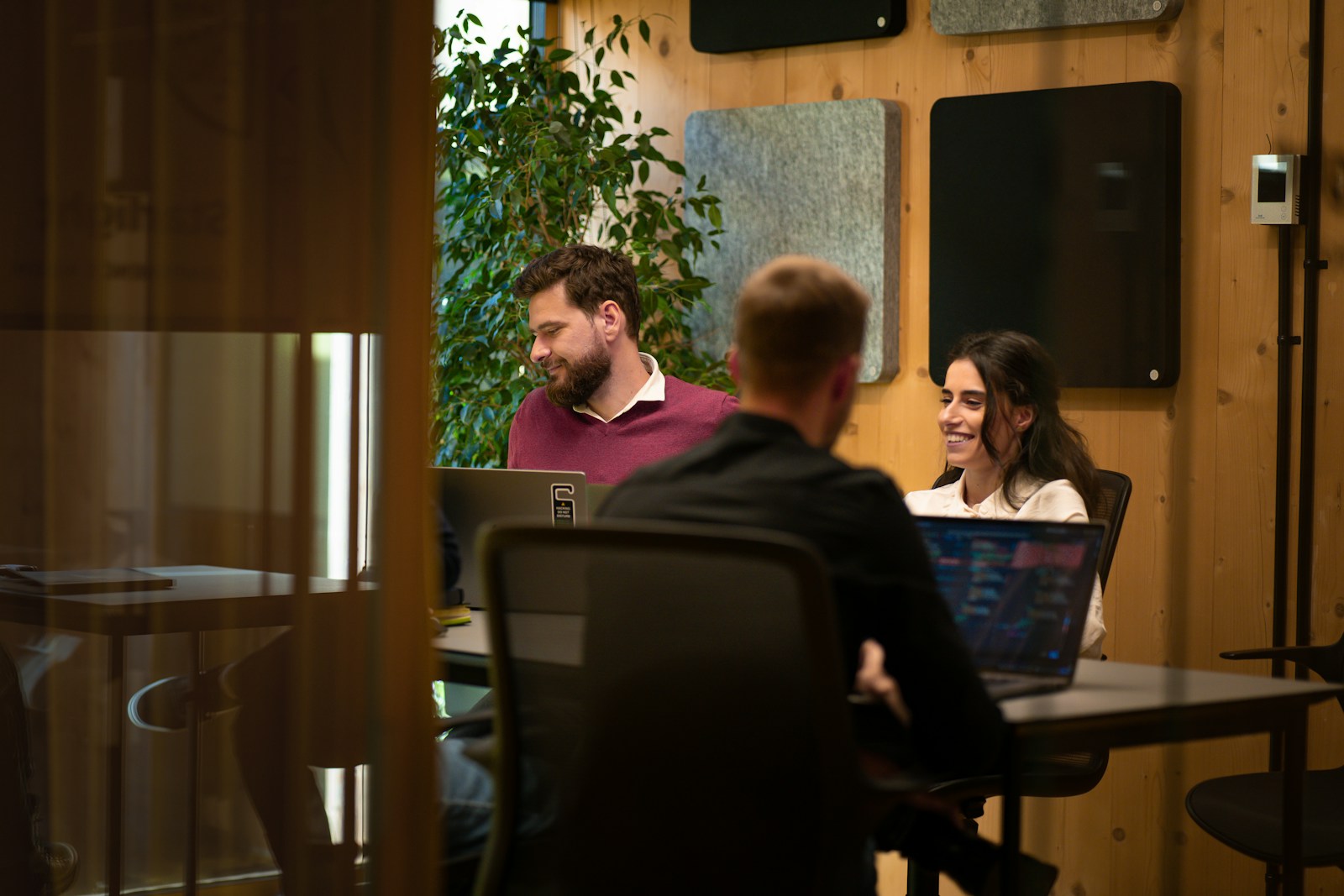 Builders collaborating around a table with laptops